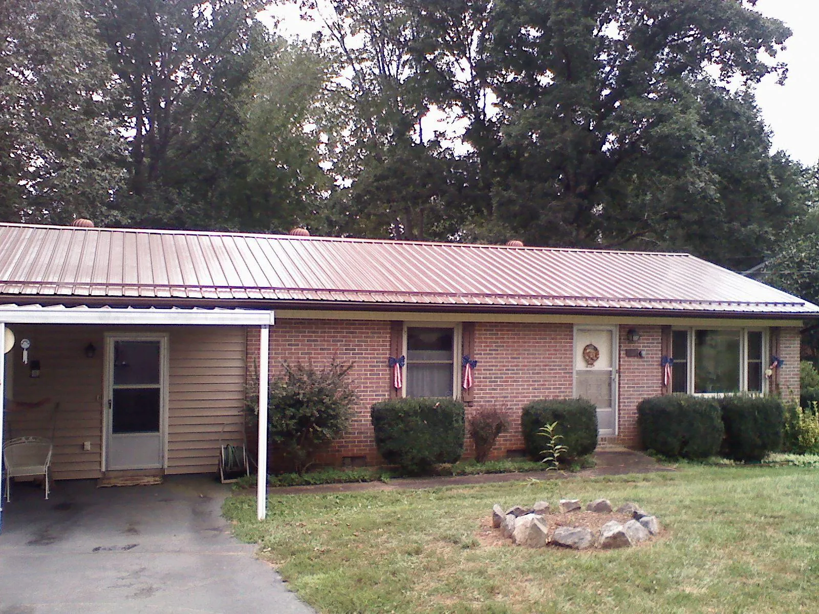 Bronze metal roof and carport on a brick ranch home — Roof Repair work by our crew in Kailua